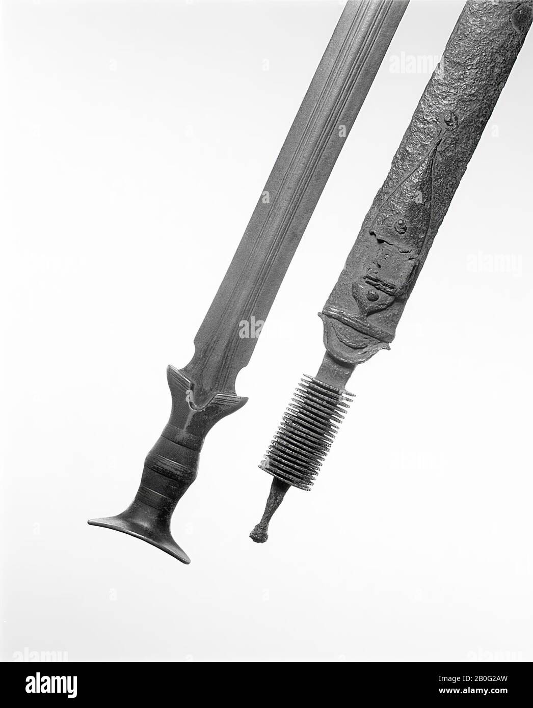 La Téne Schwert in Schabbard. Die Schabbard besteht auf der einen Seite aus  Bronze, auf der anderen Seite aus Eisen, das an den Seiten um die Bronze  geschmiedet ist. Etwas unterhalb des