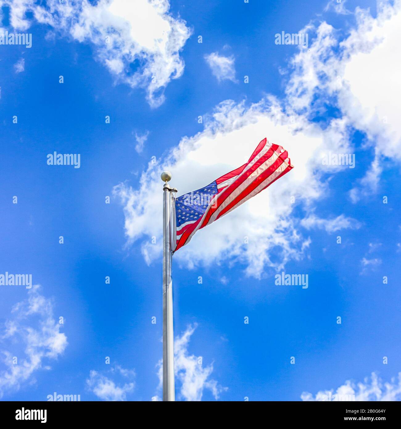 Amerikanische Flagge gegen einen blauen Himmel mit weißen Wolken Stockfoto