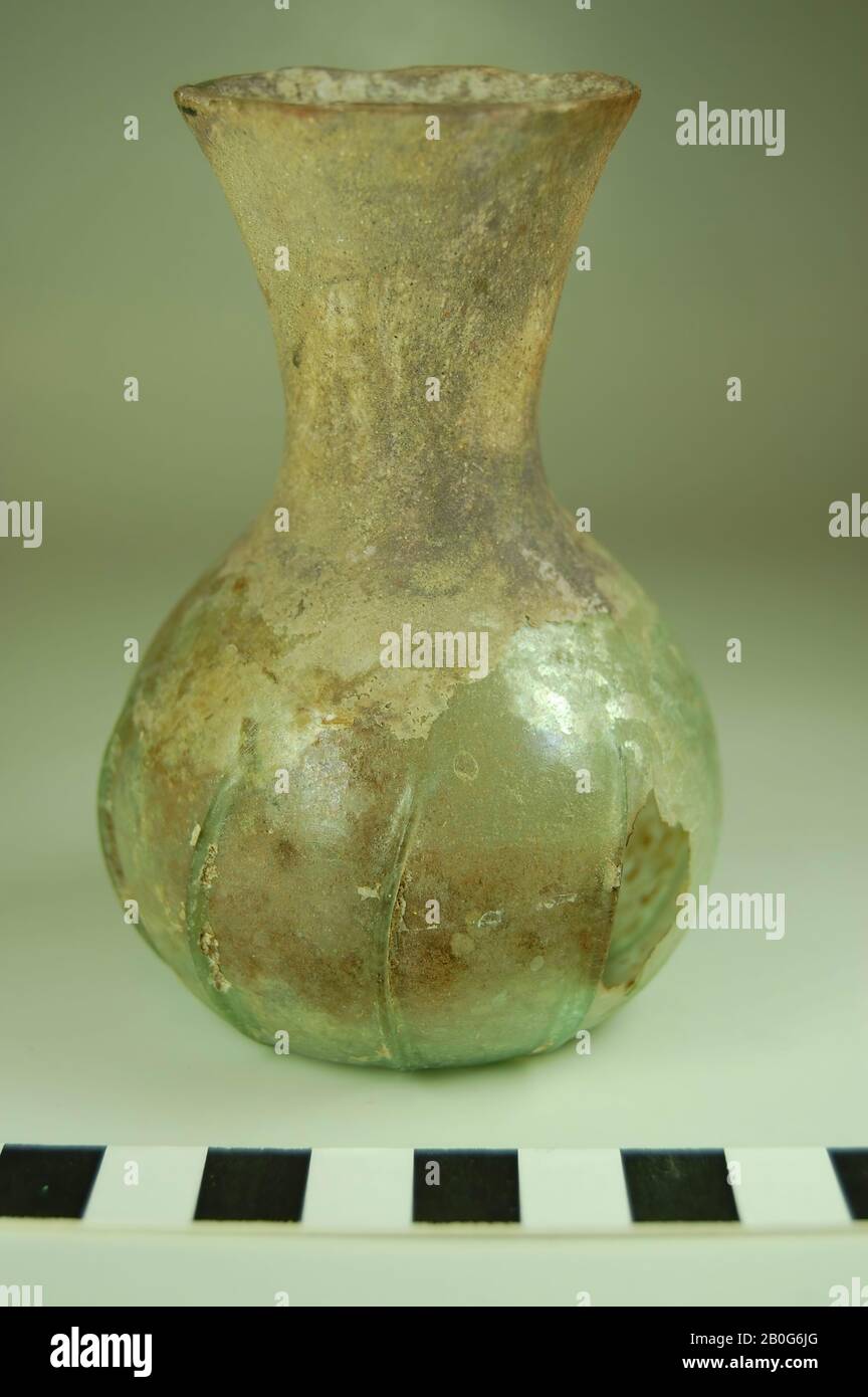 Flasche mit breitem, mehr oder weniger birnenförmigem Bauch und trichterförmigem hohem Hals. Keine profilierte Lippe. Hellgrünes Glas, teilweise (der Hals ganz) mit einer Verwitterungsschicht bedeckt. Auf dem Bauch acht vertikale, leicht nach rechts geneigten Rippen, Flasche, Glas, CA. 10 cm, römerzeit, Türkei Stockfoto
