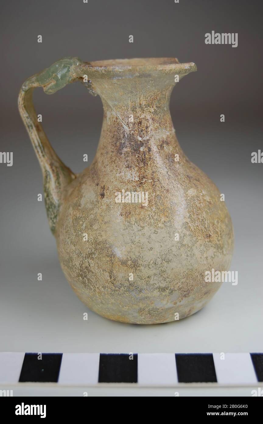 Mixbecher mit einem Ohr. Hellgrünes Glas, mit Verwitterungsschicht. Kein Standfuß. Der Boden steigt. Marke Pontil. Das Ohrstück ist umgebogen und sitzt gegen die Lippe. Es gibt ein Stück aus der Lippe, Kanne, Glas, etwa 7,2 cm, Römerzeit, Türkei Stockfoto