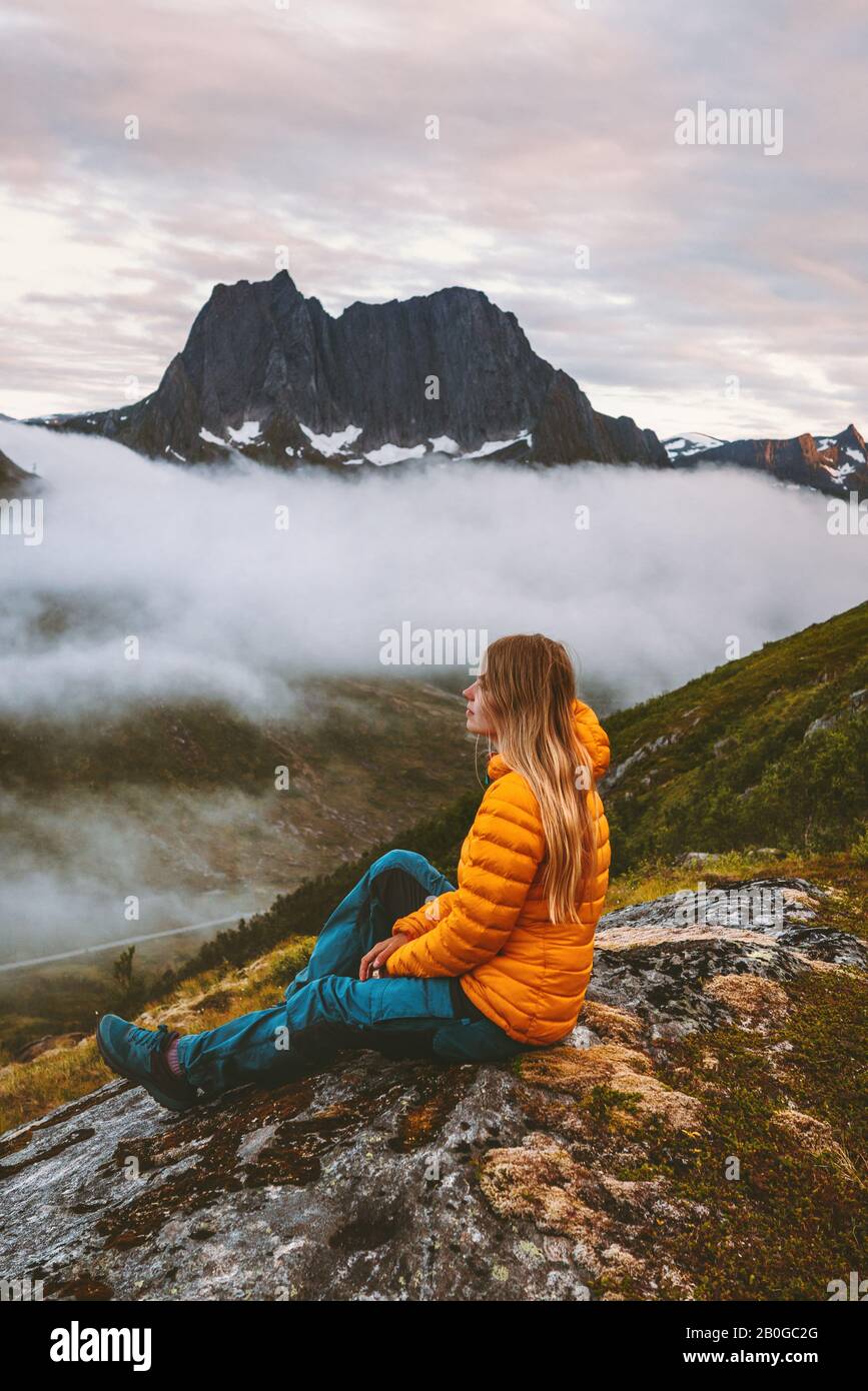 Frau mit Blick auf die Berge alleine reisen Abenteuerurlaub gesunder Lebensstil im Freien in Norwegen Ökotourismus Alleinreise Abendlandschaft Stockfoto