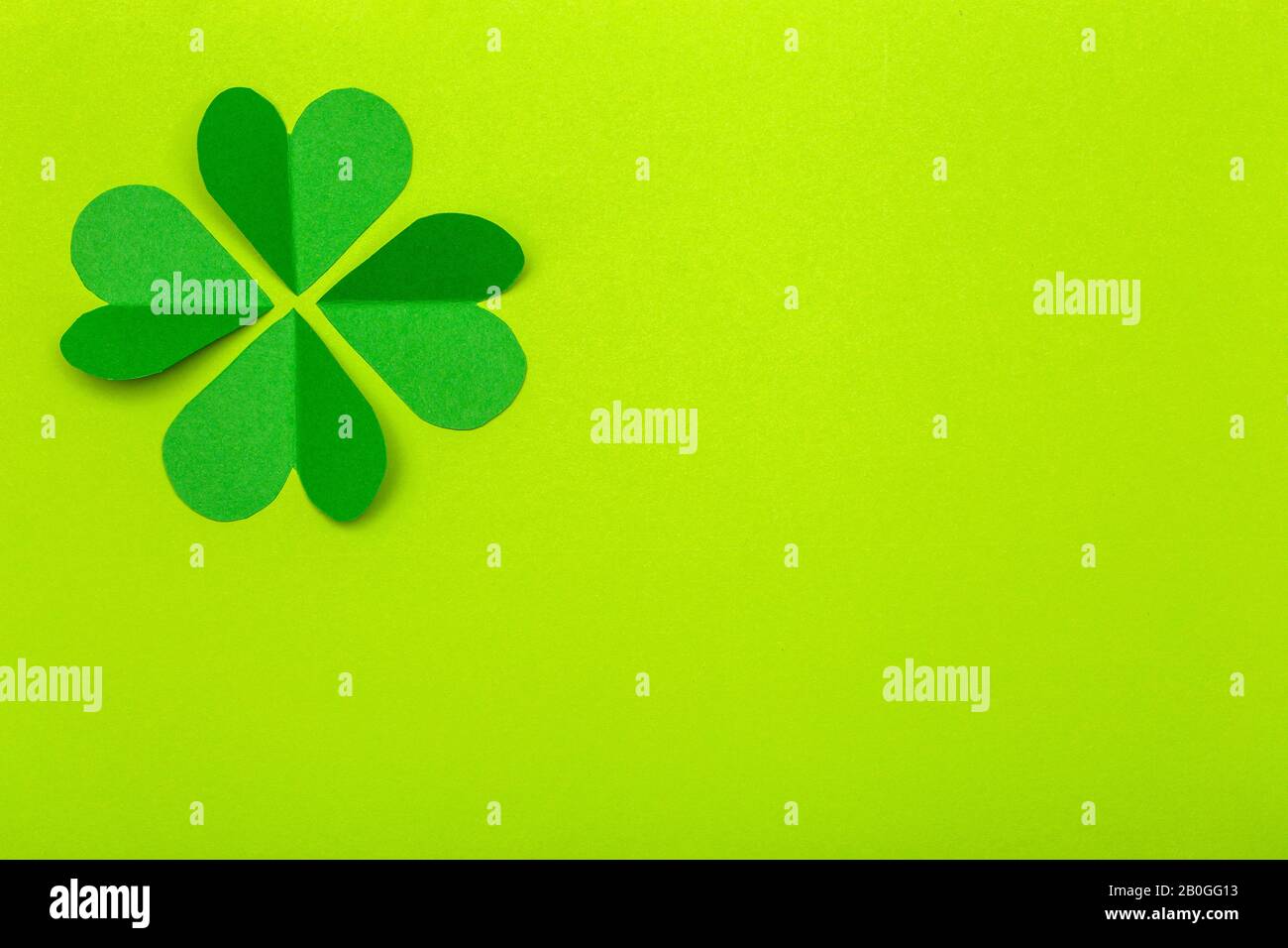 St. Patrick's Day (St. Paddy's Day) Hintergrundkonzept. Grünes Kleeblatt aus Papier auf grünem Hintergrund. Klee ist ein Symbol für Irland und keltische Kultu Stockfoto