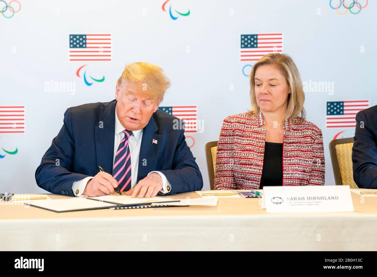 US-Präsident Donald Trump unterzeichnet ein Dokument, das die Unterstützung der Regierung für die Olympischen Sommerspiele 2028 in Los Angeles zuschreibt, da die US-amerikanische Olympische und paralympische CEO Sarah Hirshland, rechts, die Montage Beverly Hills am 18. Februar 2020 in Beverly Hills, Kalifornien, ansieht. Stockfoto