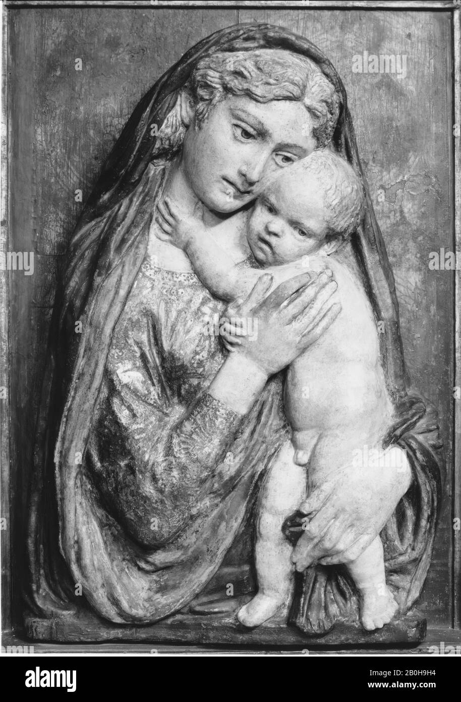 Schule von Donatello, Madonna und Kind, Italienisch, Schule von Donatello (Italienisch, Florenz Ca. 1386-1466 Florenz), 15. Jahrhundert, Italienisch, Figuren: Terrakotta, polychromiert und vergoldet; später Hintergrund: Holz, bemalt, um Brokat darzustellen; Rahmen: Geschnitzt und bemalt, Zierleisten vergoldet, Insgesamt: 30 × 20 1/2 Zoll. (76,2 × 52,1 cm), Skulptur Stockfoto