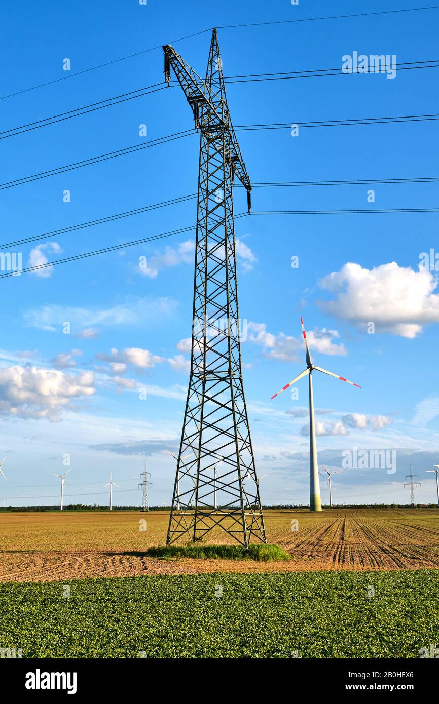 Ein Elektrizitätspylon mit Windenergieanlagen in Deutschland Stockfoto