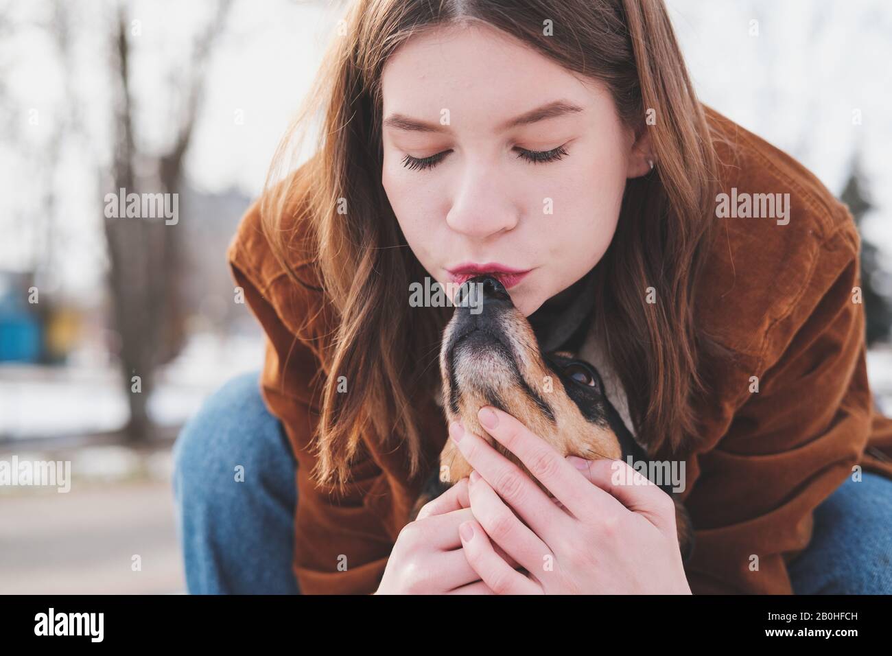 Liebevolle und liebenswürdige Haustiere Konzept: Junge Frau küsst ihren kleinen Hund Stockfoto