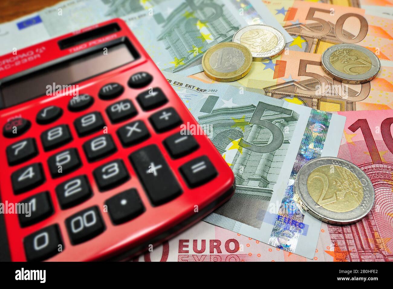 Euro-Banknoten und -Münzen und Rote-Tasche-Taschenrechner Stockfoto
