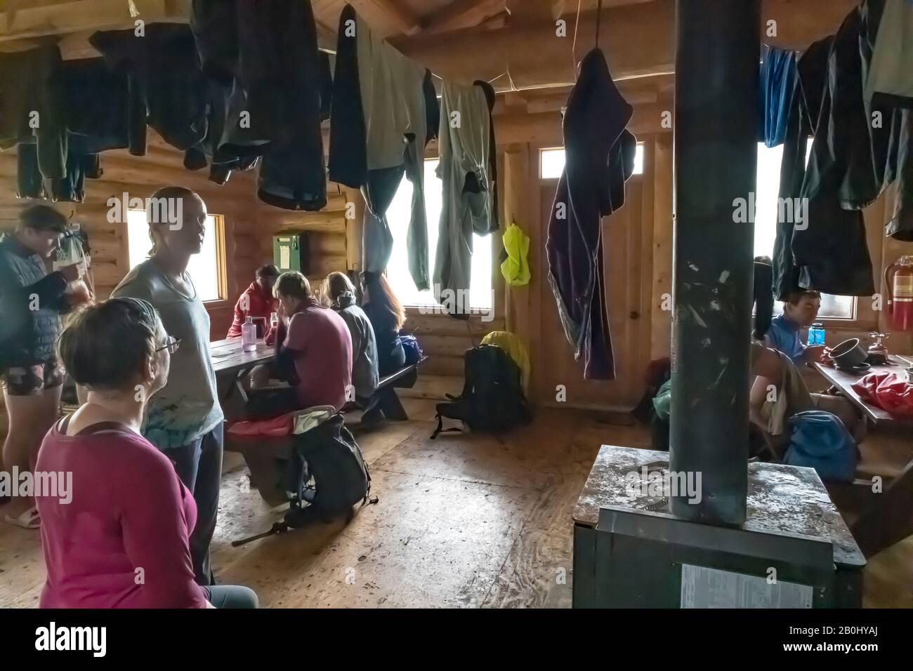 Wanderer, die während des Regenstreichens in Hargreaves Shelter am Berg Lake im Mount Robson Provincial Park, British Columbia, Kanada nasse Ausrüstung austrocknen [kein Model rel Stockfoto