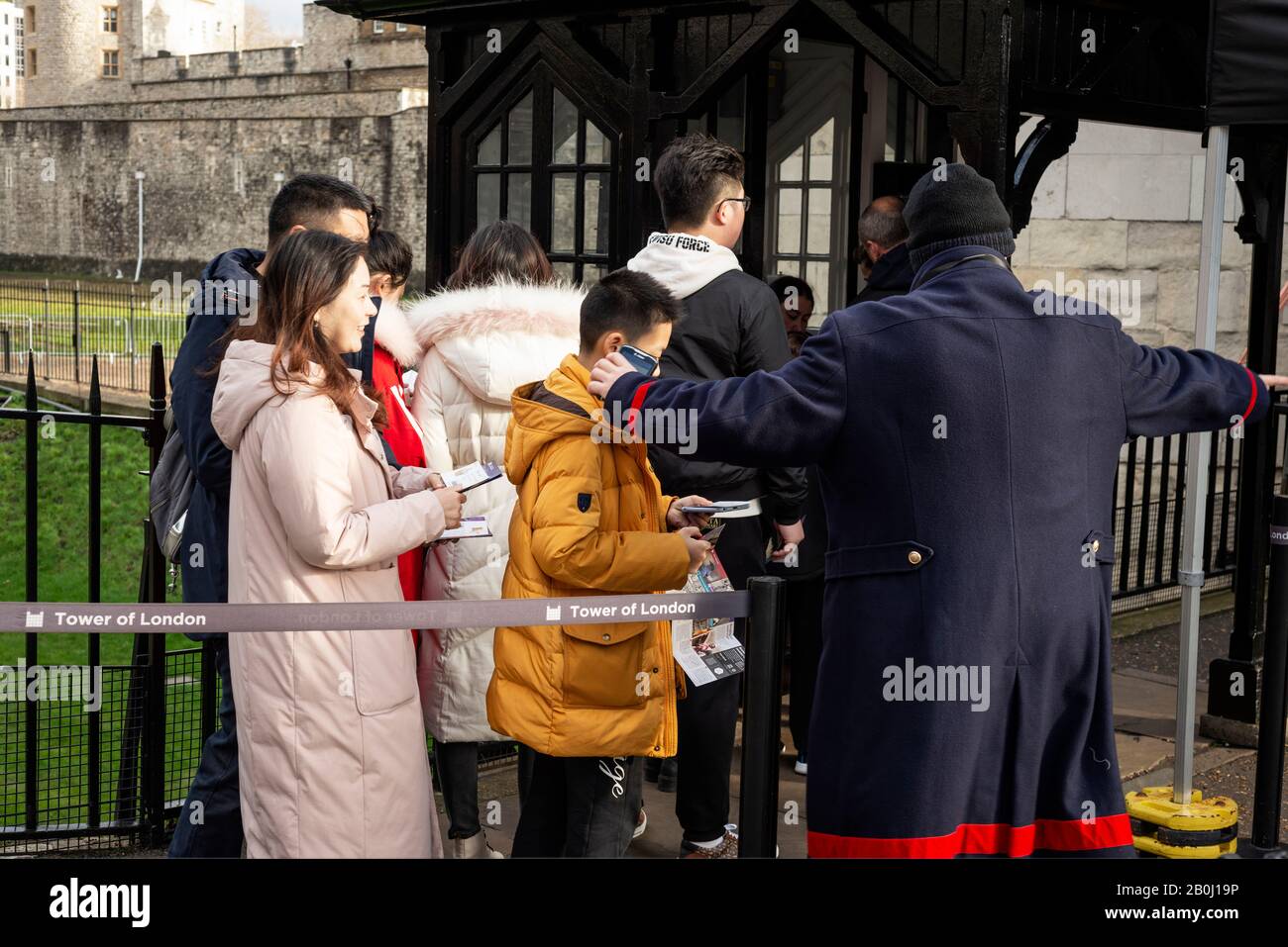 Touristen und ein Beefeater am Eingang zum Tower of London, London, Großbritannien Stockfoto