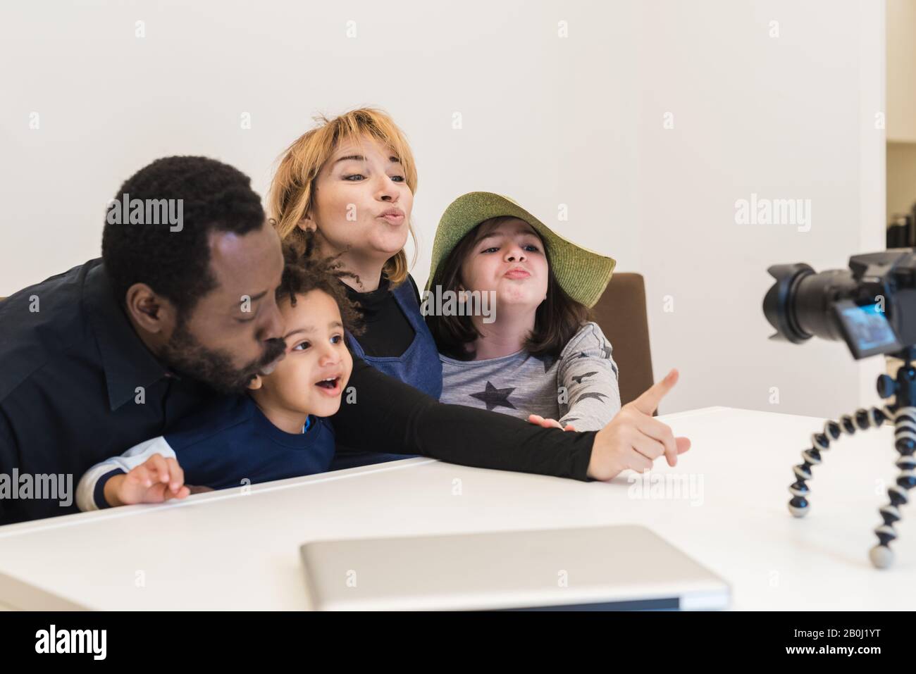 Multiethnische Familie, schwarzer Vater und weiße Mutter mit zwei gemischten Kindern schicken Küsse in einem Videoanruf an ihre Verwandten, die Familie der multirassischen Stockfoto