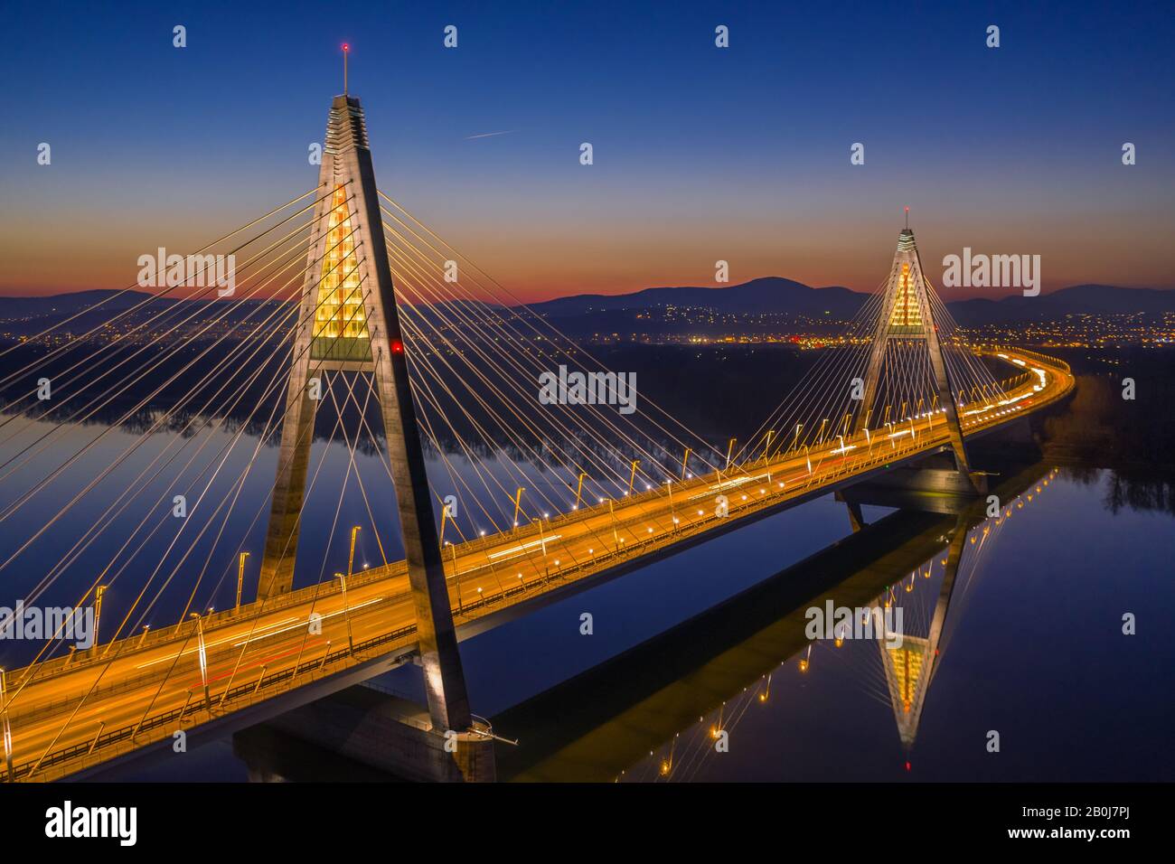 Budapest, Ungarn - Blick Auf Die beleuchtete Megyeri-Brücke in der Abenddämmerung mit hellblauem Himmel Stockfoto