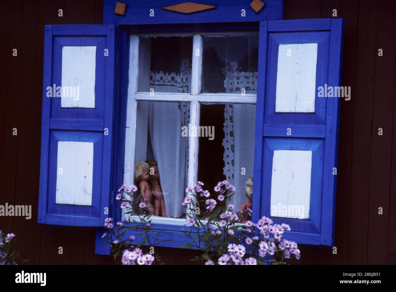 RUSSLAND, SIBIRIEN, DORF BEI NOVISIBIIRSK, BUNTES FENSTER EINES TYPISCHEN HOLZHAUSES IN DER TAIGA, PUPPEN IM FENSTER Stockfoto
