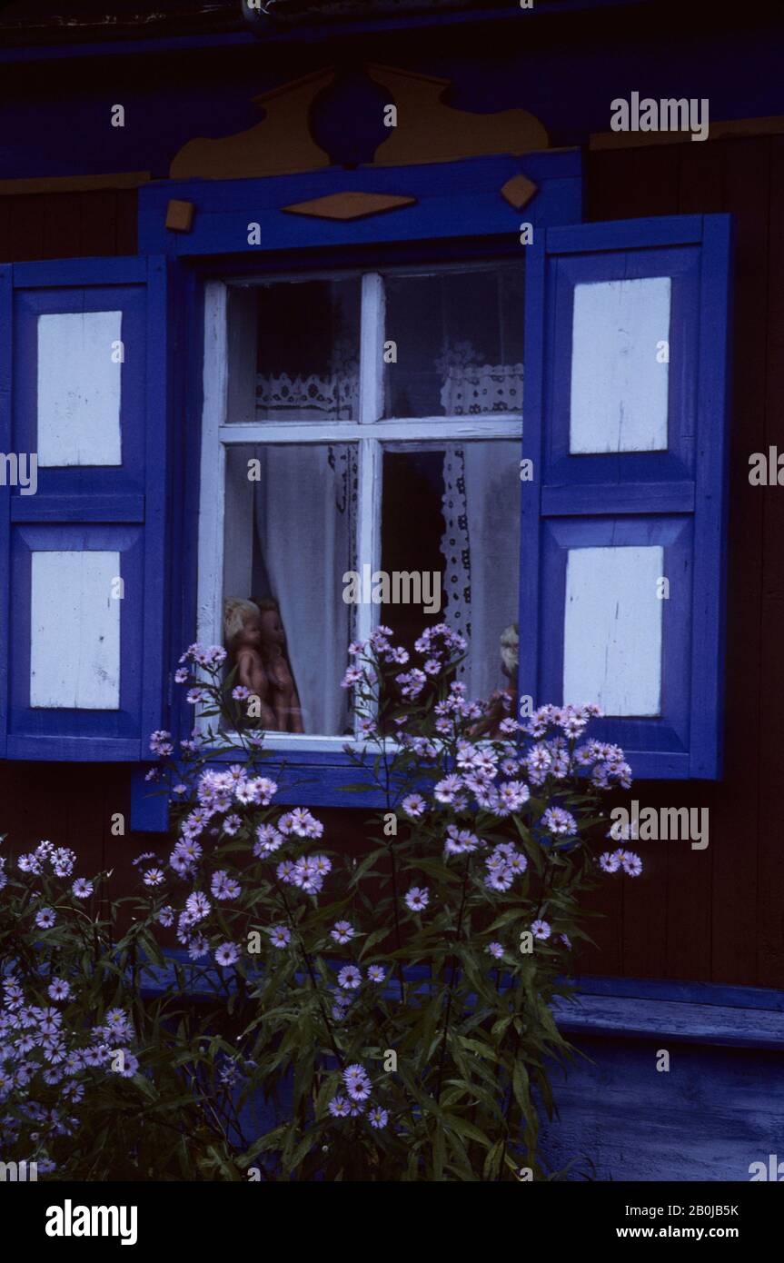 RUSSLAND, SIBIRIEN, DORF BEI NOVISIBIIRSK, BUNTES FENSTER EINES TYPISCHEN HOLZHAUSES IN DER TAIGA, PUPPEN IM FENSTER Stockfoto