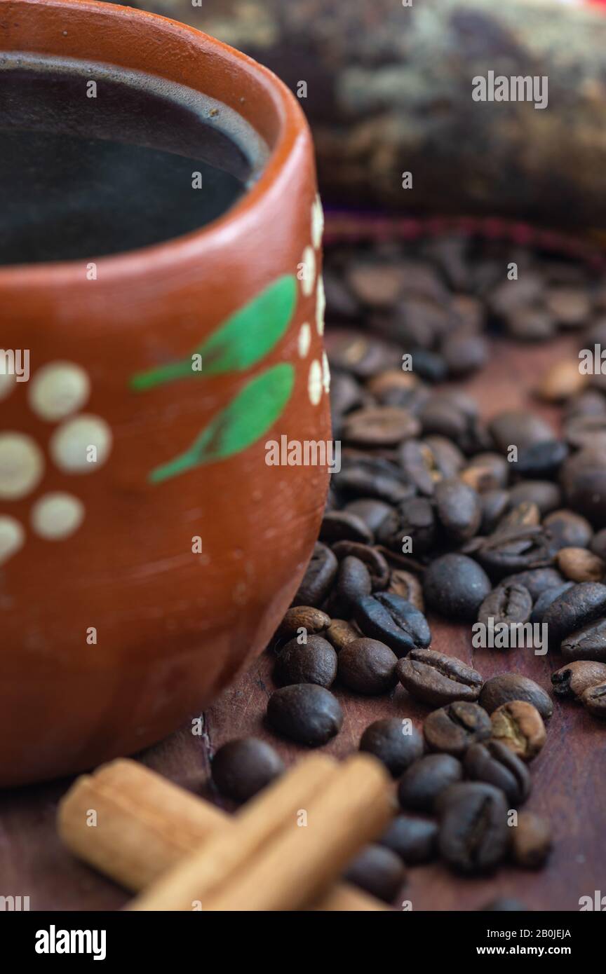 Café de Olla. Mexikanische Kaffeebohnen mit Zimt und Piloncillo und einer Tasse Kaffee Stockfoto
