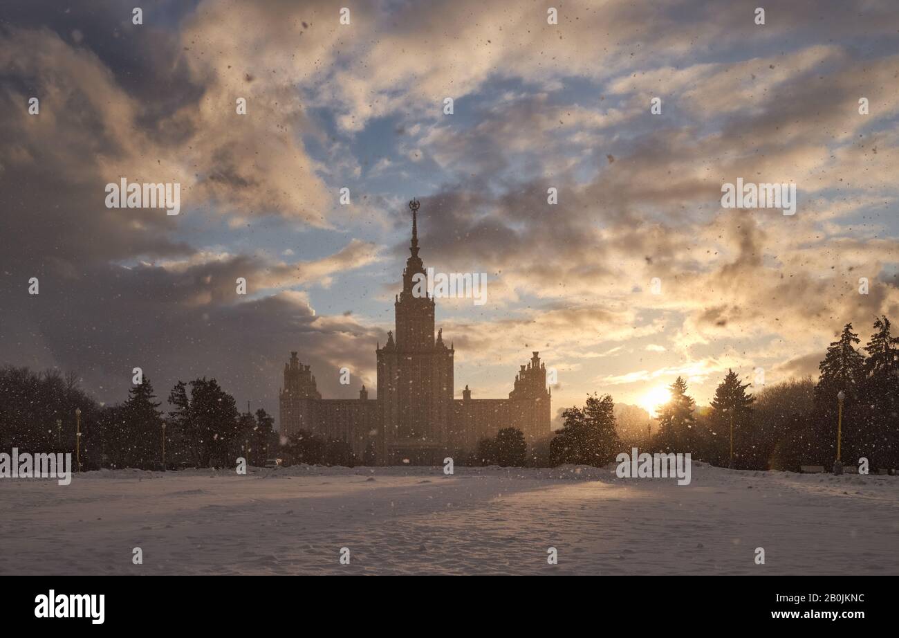 Schneefall gegen die untergehende Sonne und die Moskauer Staatsuniversität Stockfoto