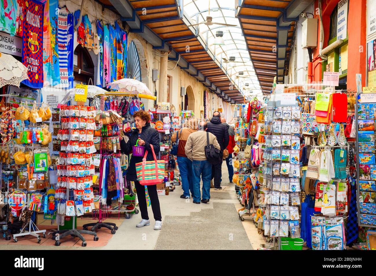 Larnaca, ZYPERN - 16. FEBRUAR 2020: Souvenirmarkt für Touristen im Pavillon, Menschen, die in Reihe zwischen Geschäften mit Waren laufen Stockfoto