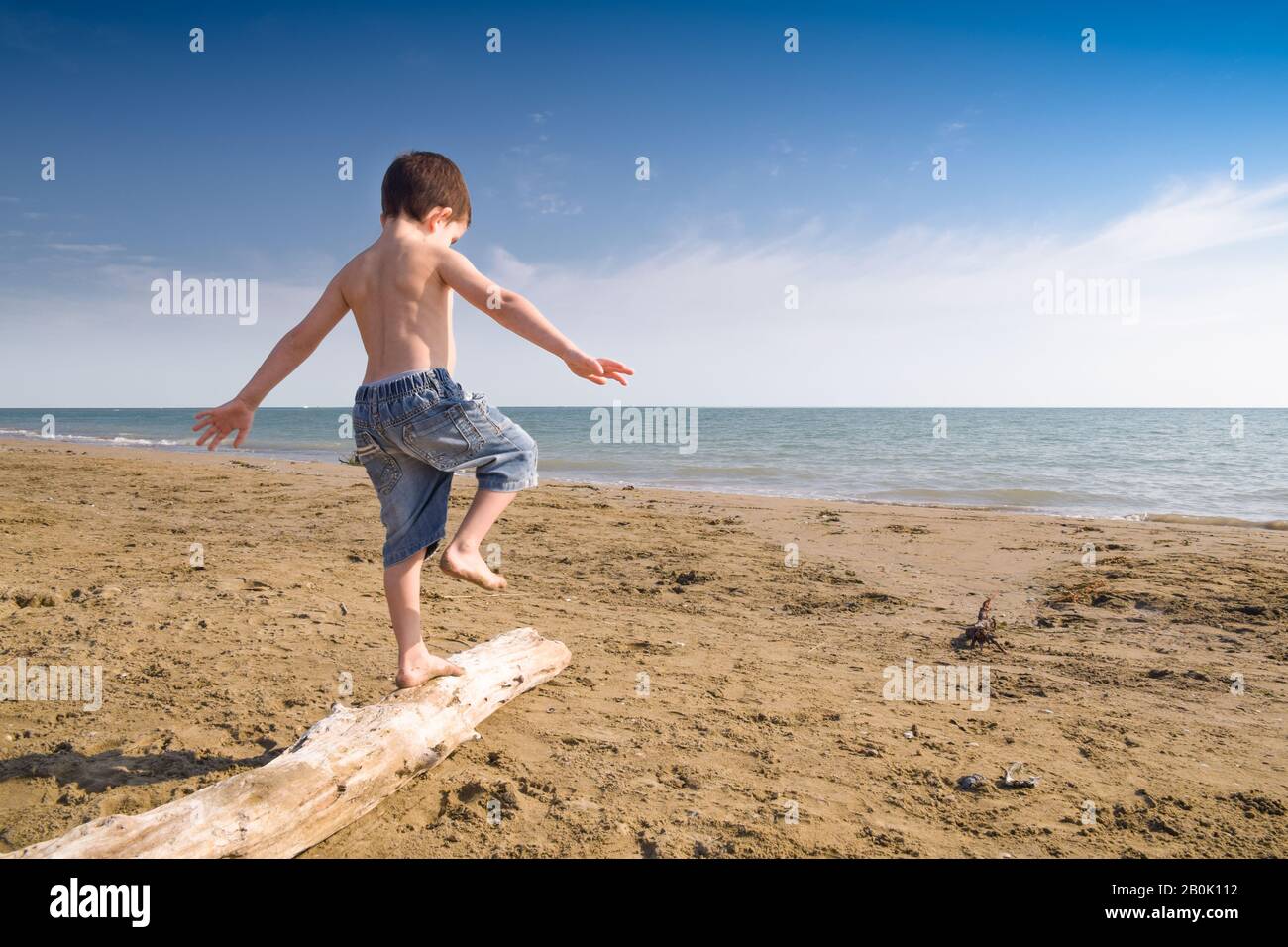 Ein Junge, der auf einem sandigen Strand steht Stockfoto