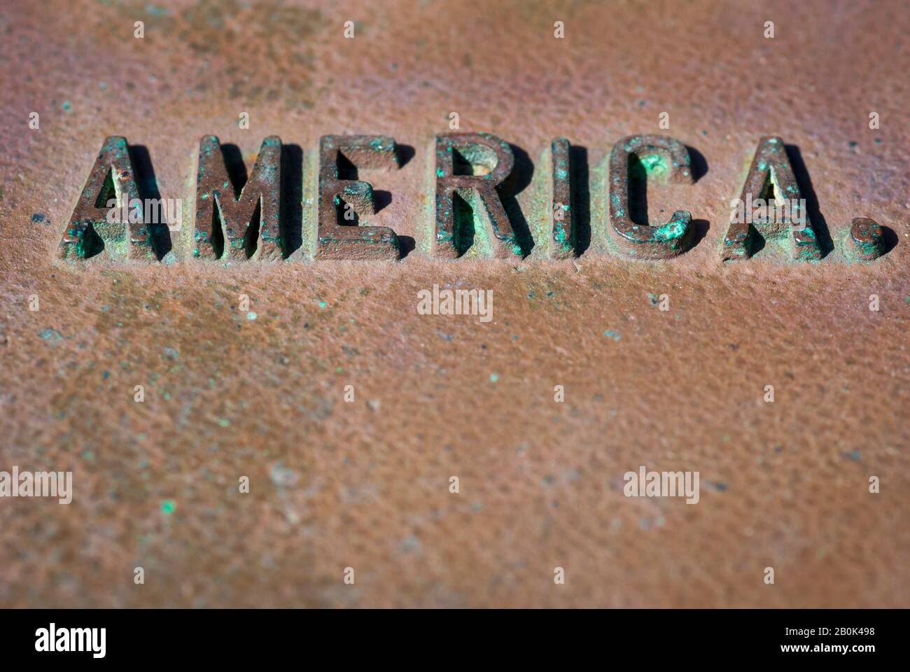 Wetterbotschaft Amerika in erhabener Schrift mit grünen Patina-Splinten mit Metall-Kopierraum Stockfoto