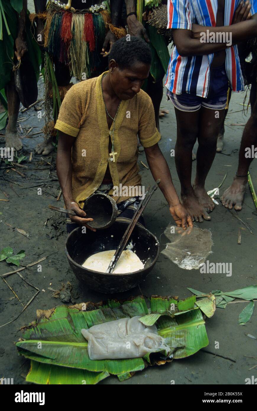 NEUGUINEA, FLUSS SEPIK, PRIMITIVE FRAU, DIE SAGO ZUM ESSEN VORBEREITET, AUF BANANENBLÄTTERN Stockfoto