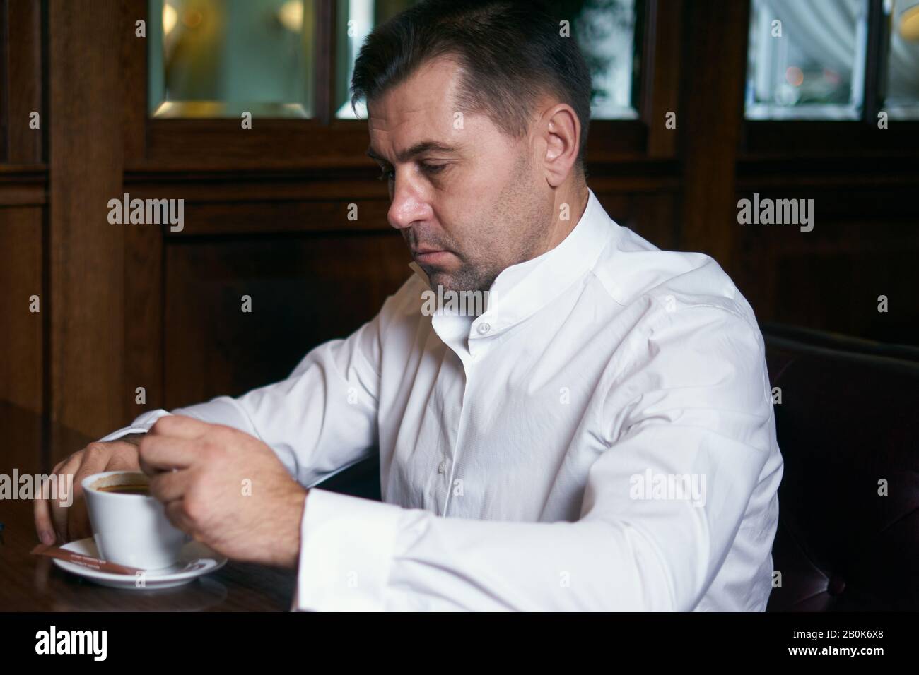 Junger Mann trinkt auf der Straße Kaffee, während er einen Tablet-Computer verwendet Stockfoto