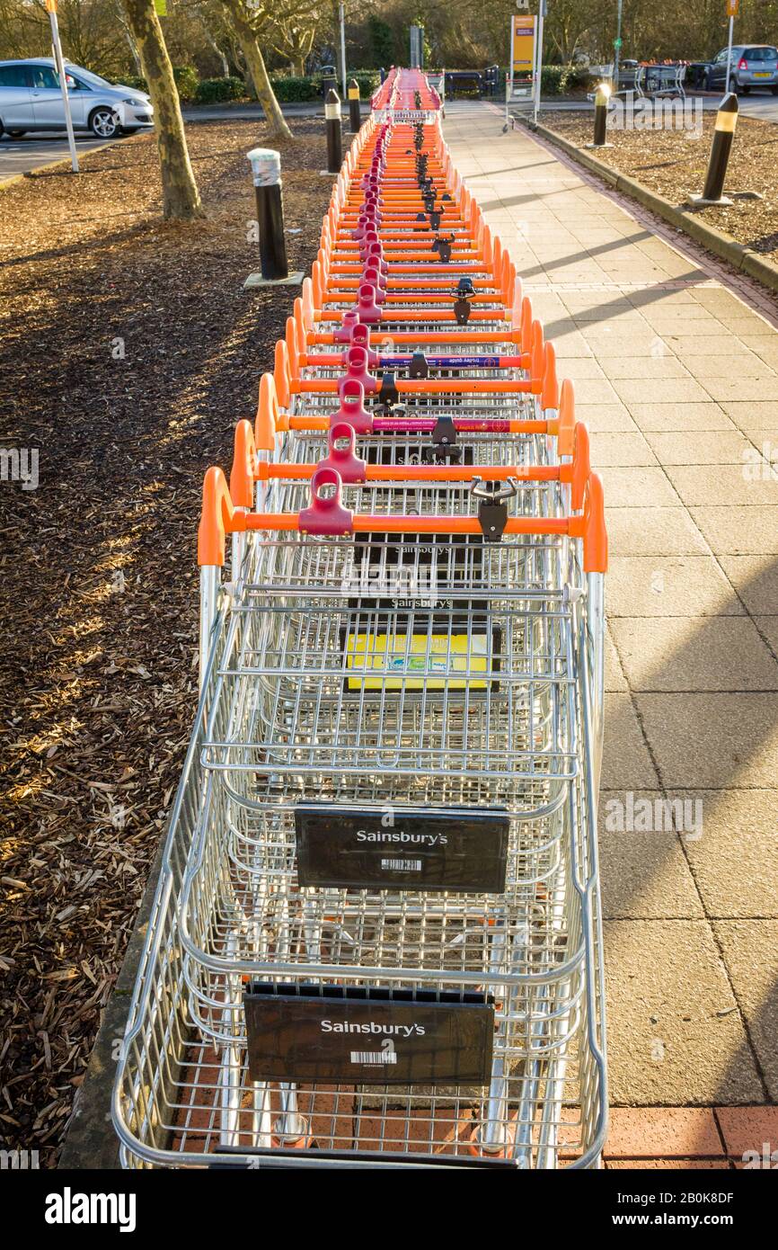 Eine Reihe leerer Einkaufswagen, die auf eine Kundenauswahl außerhalb des Sainsburys Supermarktes in Chippenham Wiltshire England UK warten Stockfoto