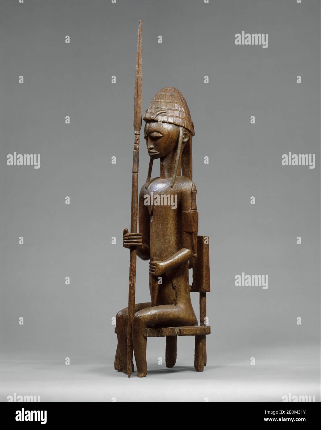 Sitzende männliche Figur mit Lance, Bamana-Völkern, 16. Bis 19. Jahrhundert, Mali, Bougouni oder Dioila-Region, Bamana-Völker, Holz, H. 35 1/2 Zoll × W. 9 Zoll × D. 13 1/2 Zoll (90,2 × 22,9 × 34,3 cm), Andere ((F)): 9 Zoll × 10 3/8 Zoll (22,9 × 26,4 cm), Andere ((Lance)): 44 Zoll (11,8 cm), Wood-Sculpture Stockfoto