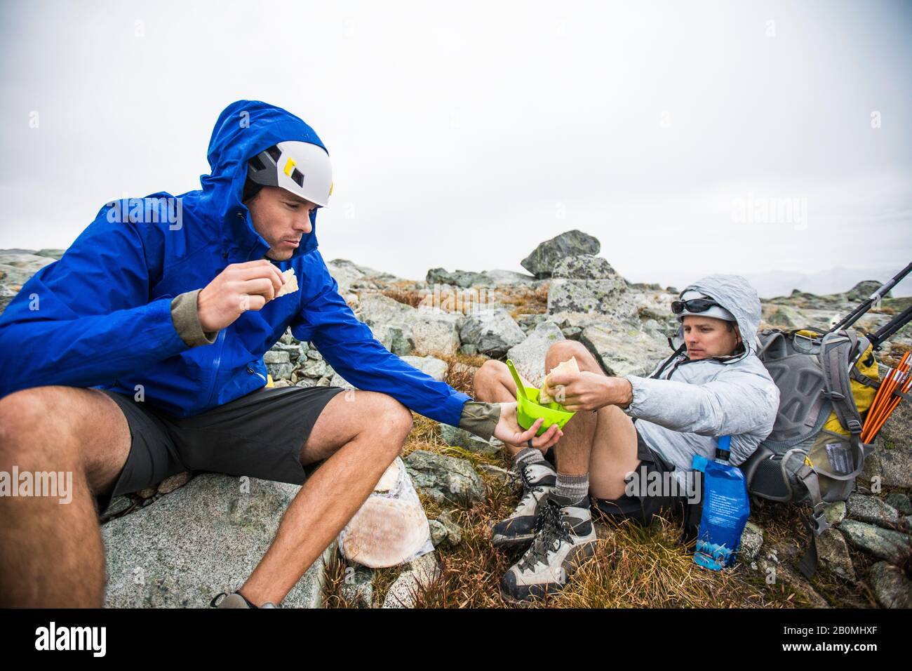 Bergsteiger teilen sich während einer Rucksacktour Essen. Stockfoto