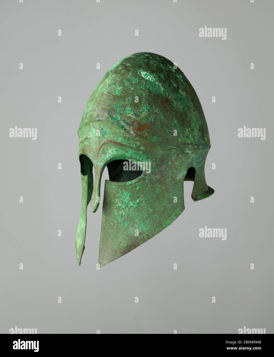 Helm des korinthischen Typs und Paar Greaves, Griechisch, Anfang 5. Jahrhundert v. Chr., Griechisch, Bronze, Helm: H. 12 1/16 Zoll (30,6 cm); W. 7 1/4 Zoll (18,5 cm); D. 10 13 / 16 Zoll (27,4 cm); Wt. 2 lb. 0,85 oz. (931 g); rechtes Schmierfett: H. 15 3/8 Zoll (39,1 cm); W. 4 15/16 Zoll (12,5 cm); D. 6 3/8 Zoll (16,2 cm); Wt. 1 lb. 2,5 oz. (525 g); linke Schmierfalle: H. 15 7/16 Zoll (39,2 cm); W. 5 1/4 Zoll (13,3 cm); D. 6 1/16 Zoll (15,4 cm); Wt. 1 lb. 1,4 oz. (492 g), Armor Parts Stockfoto