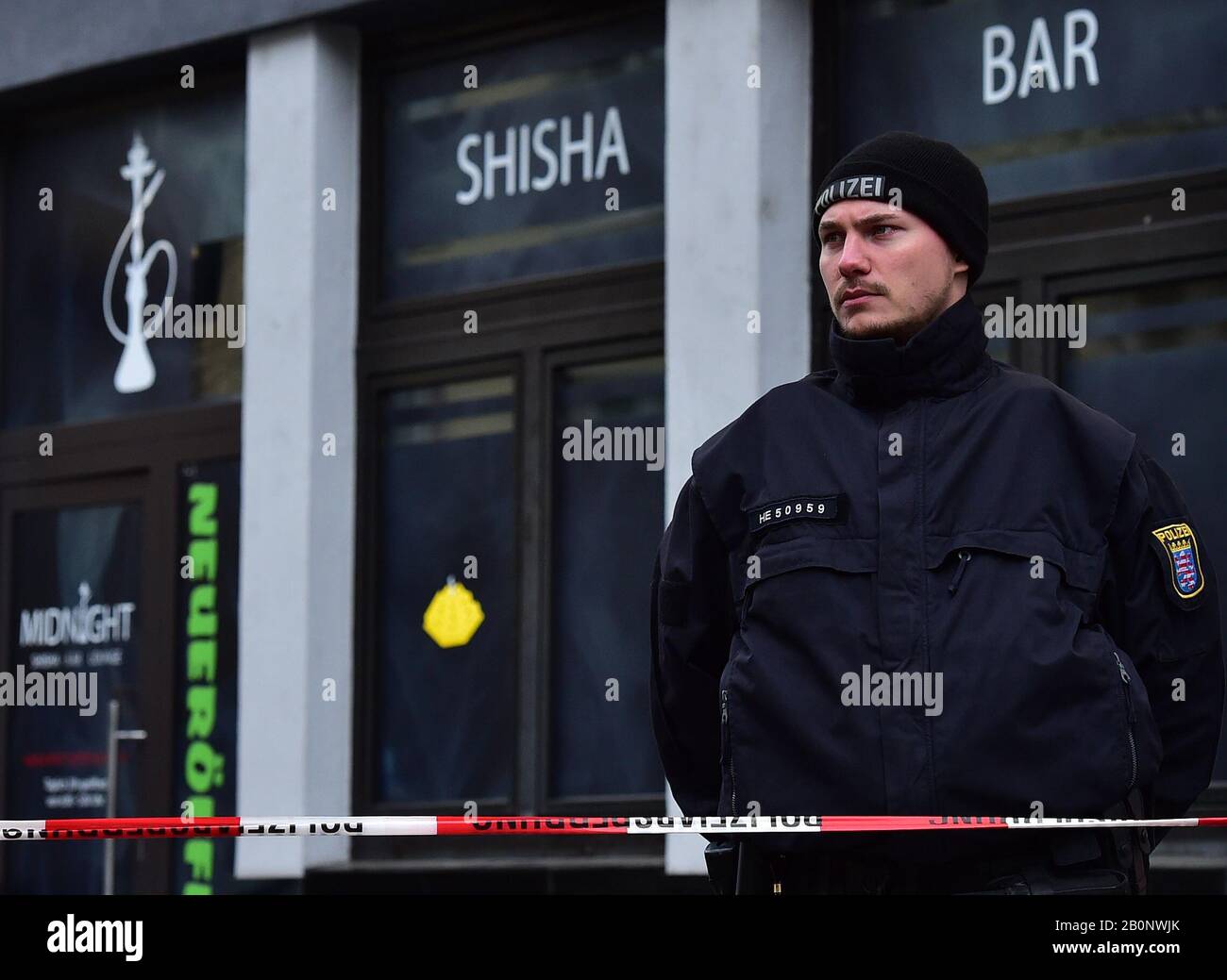 Hanau, Deutschland. Februar 2020. Ein Polizist steht Wache vor dem Ort einer der Zwillingsshootings in Hanau, 20. Februar 2020. Der mutmaßliche Schütze, der am späten Mittwoch in der westdeutschen Stadt Hanau neun Menschen bei Zwillingserschießungen erschoss und tötete, hatte ein "fremdenfeindliches Motiv", sagten Polizei und Beamte am Donnerstag. Credit: Lu Yang/Xinhua/Alamy Live News Stockfoto