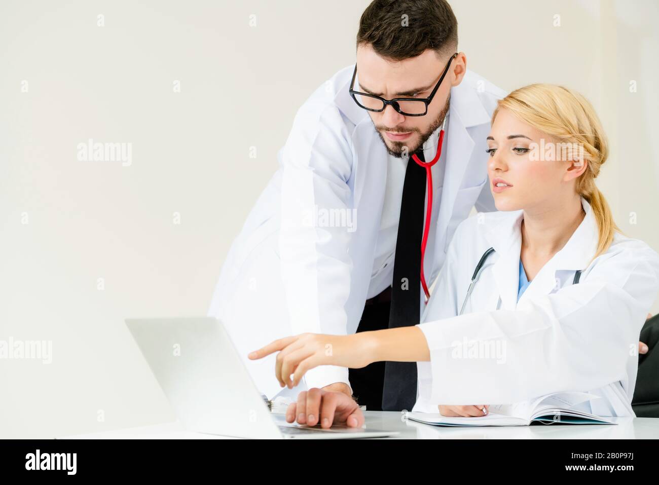 Arzt am Krankenhaus Büro Arbeiten am Laptop auf dem Tisch mit einem