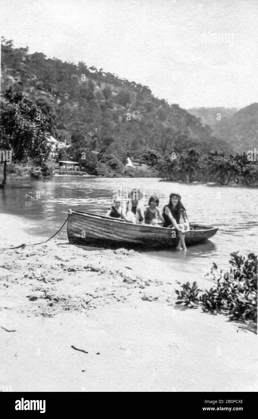 Ein Schwarz-Weiß-Bild von 1922 von vier Frauen, die in einem Holz-Ruderboot an einem Strand am Hawkesbury River in der Nähe von Brooklyn, New South Wales, Australien sitzen Stockfoto