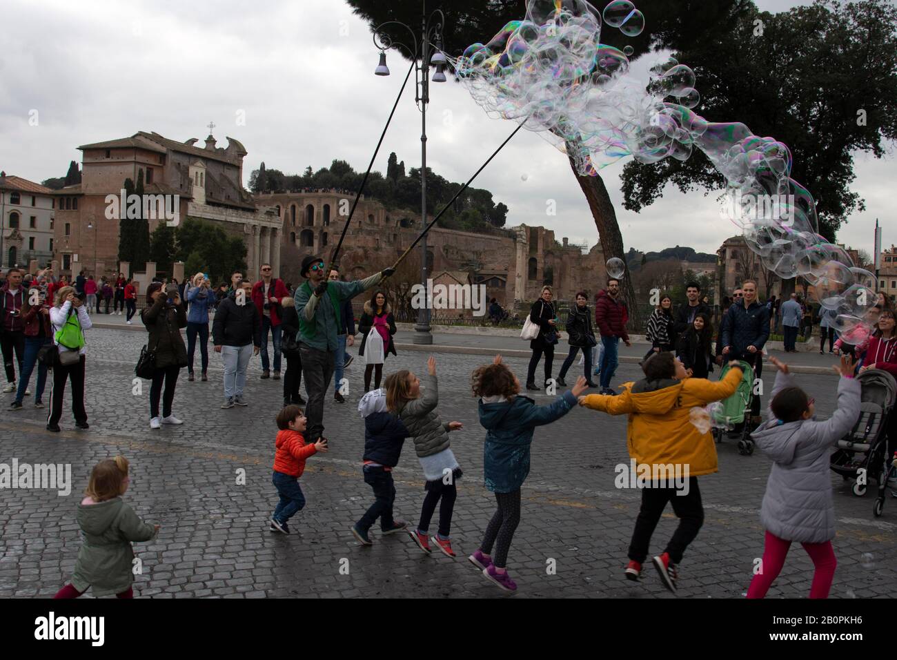 Kinder haben Spaß mit Seifenblasen auf den Straßen in der Nähe des Kolosseum, Rom, Italien Stockfoto