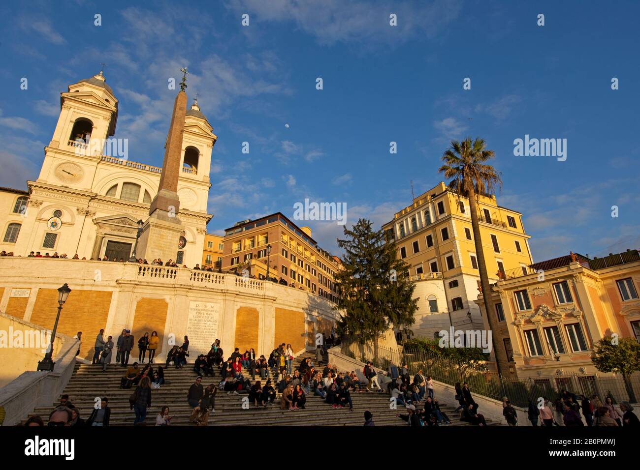 Die Menschen genießen den Sonnenuntergang auf der spanischen Treppe vor der Kirche Trinita dei Monti auf der Piazza di Spagna, Rom, Italien Stockfoto