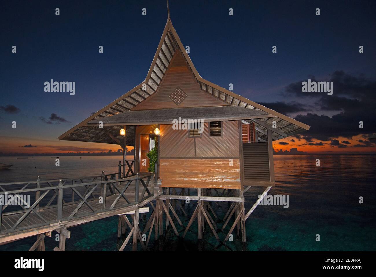 Sonnenaufgang und -bungalow auf Stelzen, die als Unterkunft im Kapalai Dive Resort, Kapalai, Malaysia, genutzt werden Stockfoto