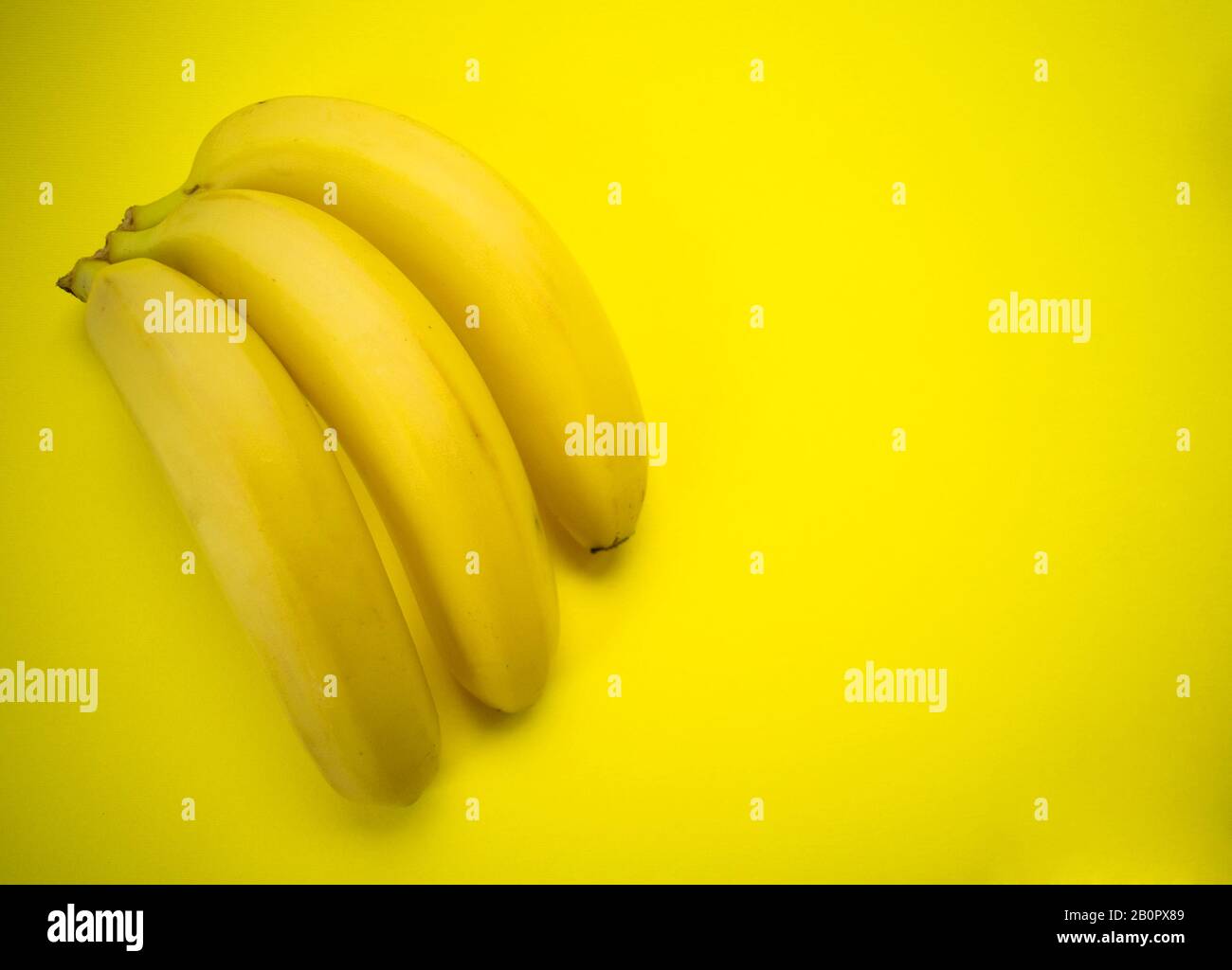 Drei Bananen auf gelbem Grund. Kopierbereich. Stockfoto