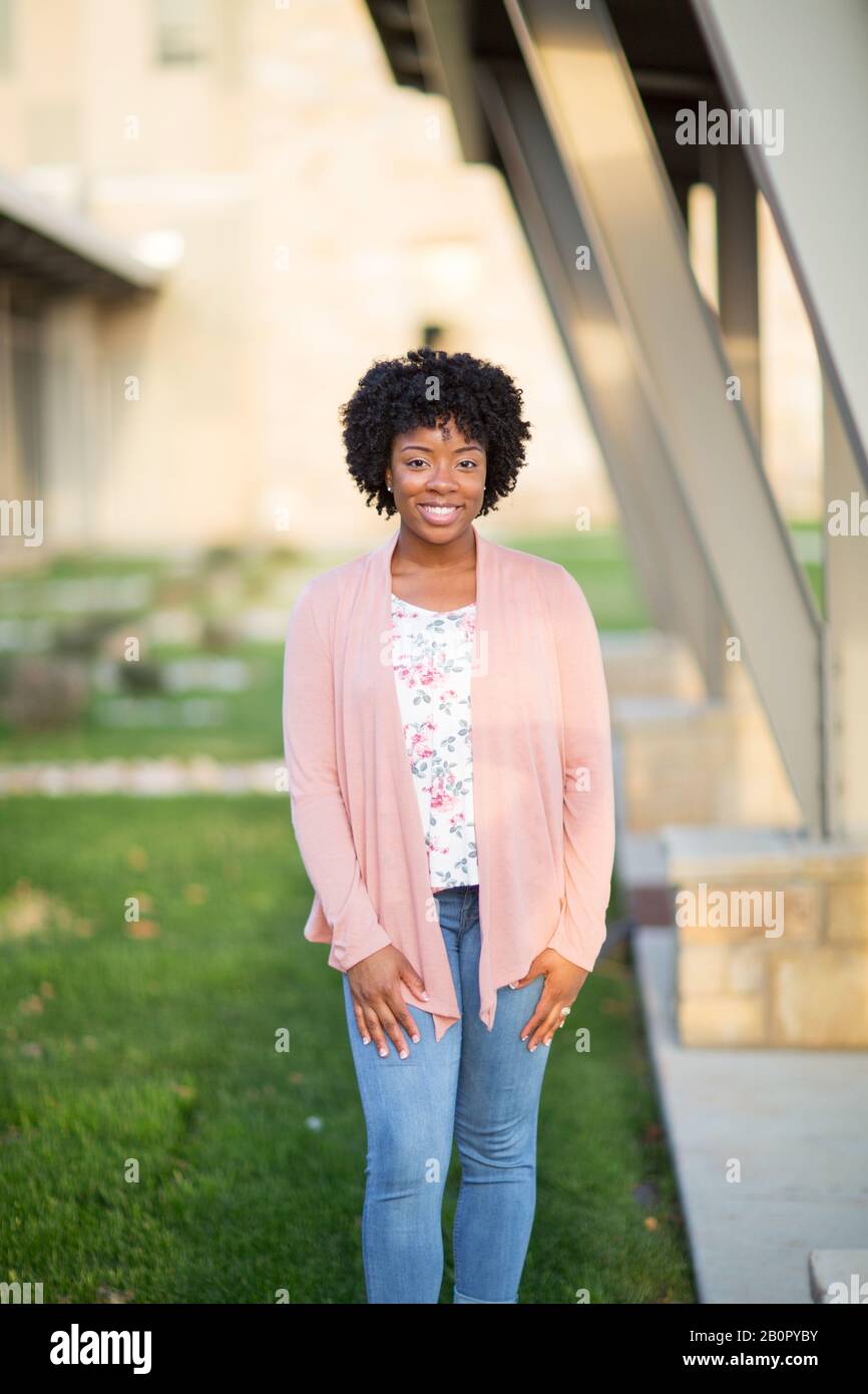 Glückliche afroamerikanische Frau lächelnd und draußen stehen. Stockfoto