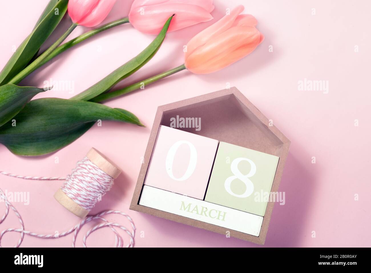 8. März Happy Women's Day Konzept. Mit Holzblockkalender und rosafarbenen Tulpen Stockfoto