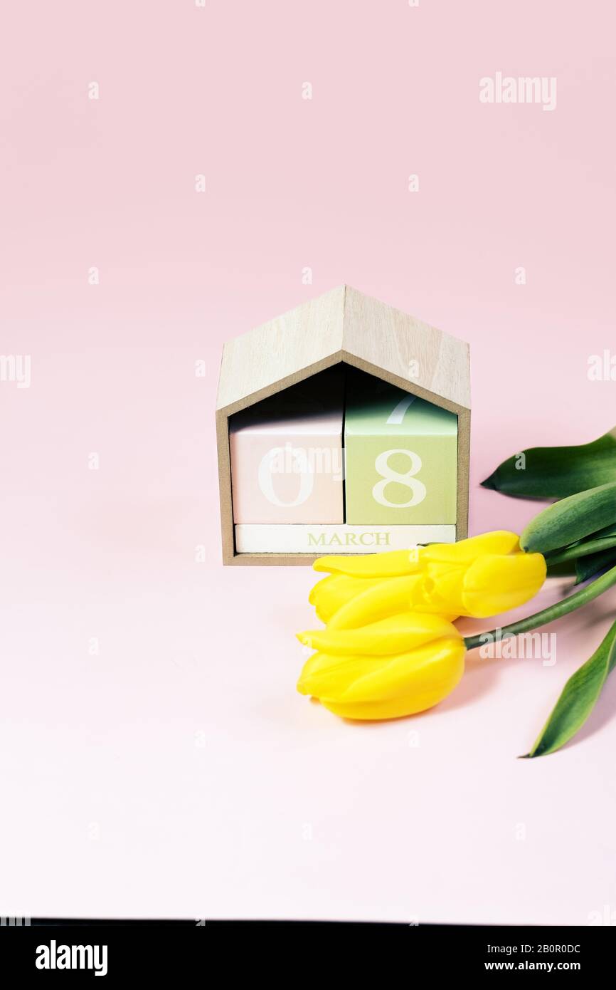 8. März Happy Women's Day Konzept. Mit Holzblockkalender und rosafarbenen Tulpen Stockfoto