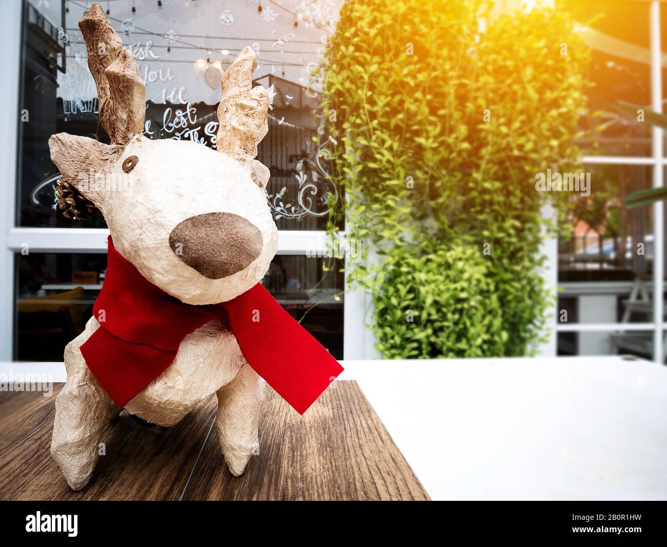 weihnachtsfeiertage Dekorationen und Rentiere vor Spiegel Glas mit Licht. Home dekorieren für weihnachten. Frohe weihnachten zwei Paar Rentiere Stockfoto