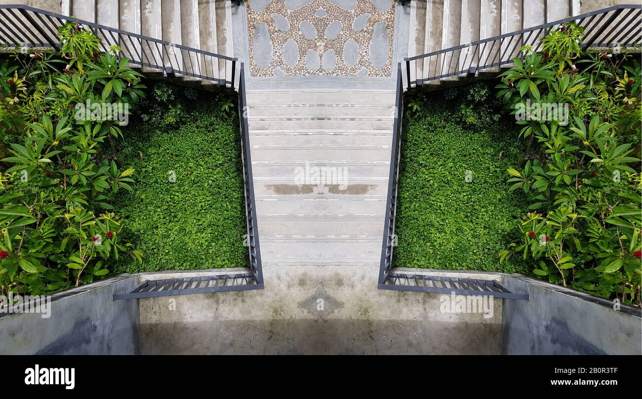 Zementieren Sie die Freitreppe in den grünen Garten. Moderne Treppe. Symmetrietreppe Foto. Außendekoration im Freien Stockfoto