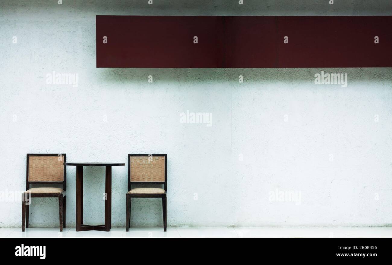 Zwei Holzsessel außerhalb der weißen Wand mit Platz. Außenwand-Hintergrundkonzept. Stockfoto