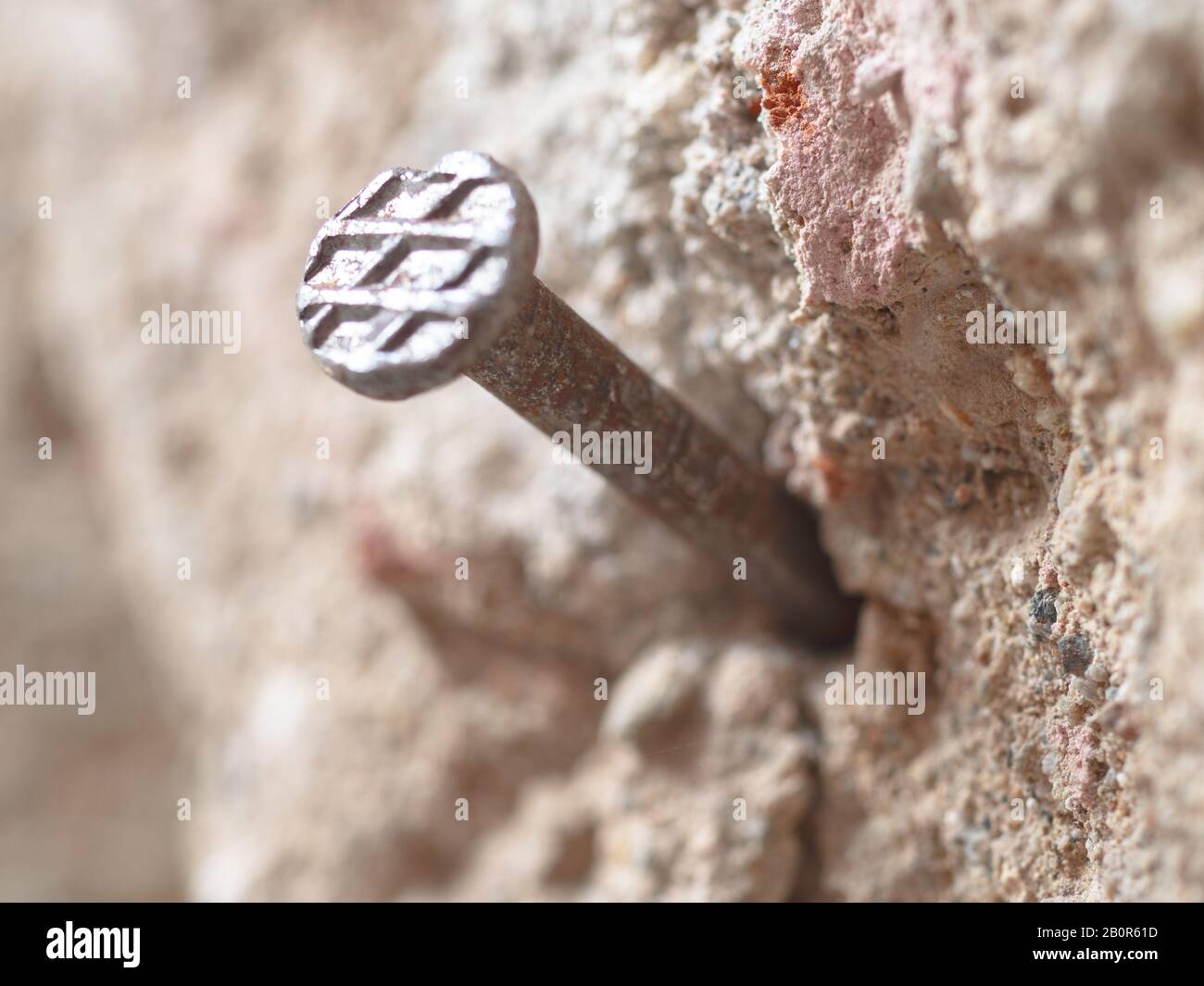 Nahaufnahme von verrosttem Nagel in alter Stein- und Betonwand  Stockfotografie - Alamy