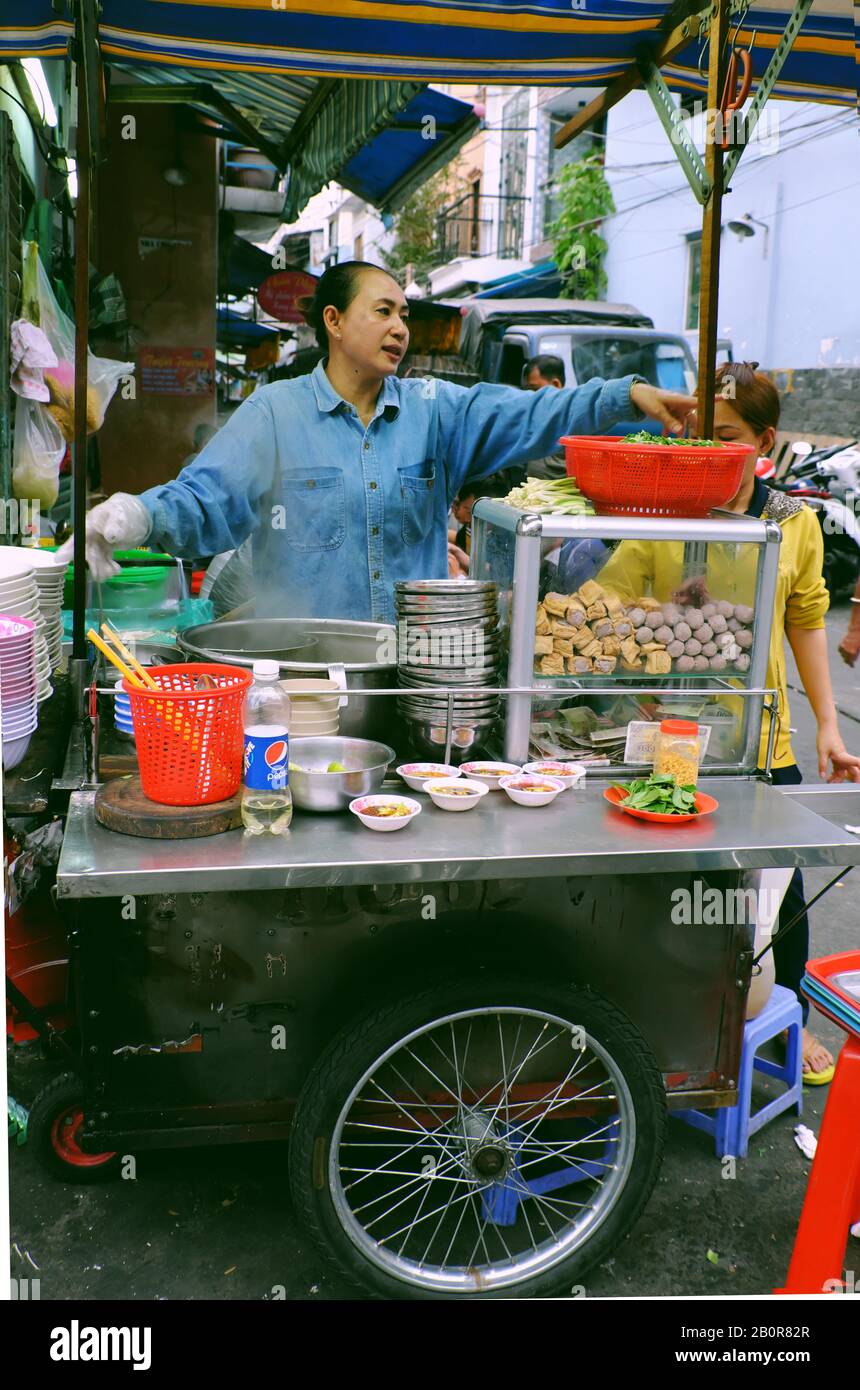 HO CHI MINH STADT, VIET NAM, vietnamesische Köchin kochen Nudeln Suppe im Restaurant im Freien, große Topf, Zutat Essen auf Wagen, mobile Lebensmittel-Stand Stockfoto