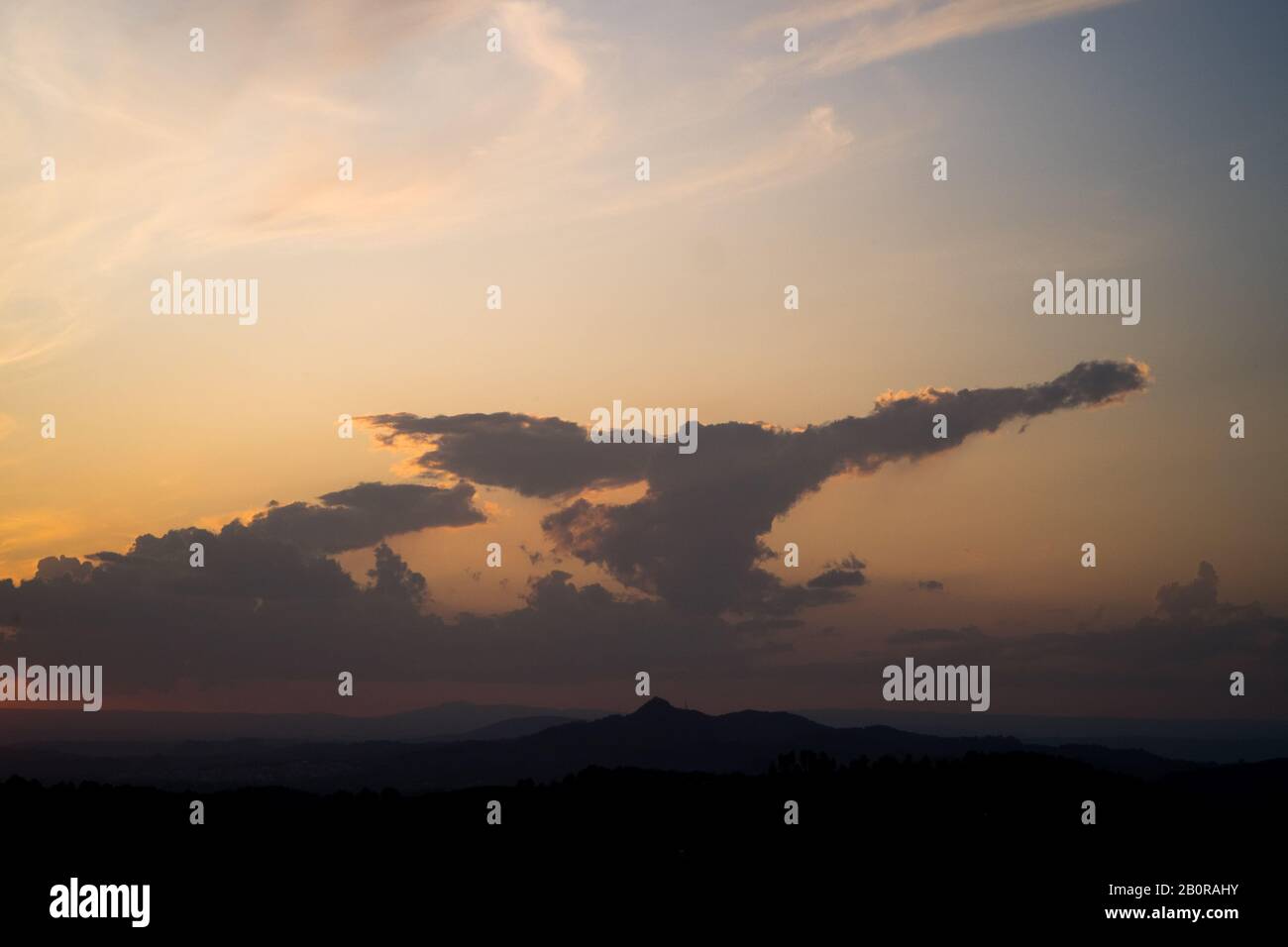 Eine adlerartig aussehende Wolkenbildung über den Hügeln der Region Valenciana bei Sonnenuntergang Stockfoto