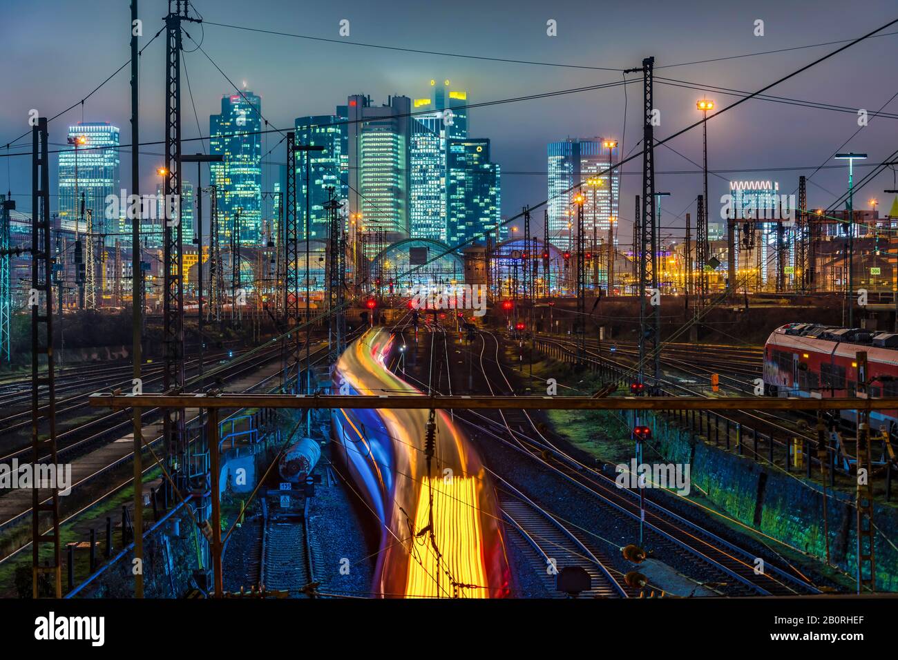 Fahrzug vor dem Hauptbahnhof Frankfurt am Main vor der Skyline, farbenfroh beleuchtet, Frankfurt, Hessen, Deutschland Stockfoto