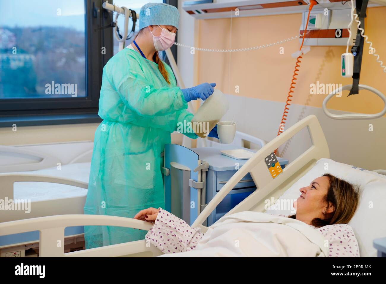 Die Krankenschwester auf der Infektionsstation im Krankenhaus gibt Tee an den Patienten, Karlsbad, Tschechien Stockfoto