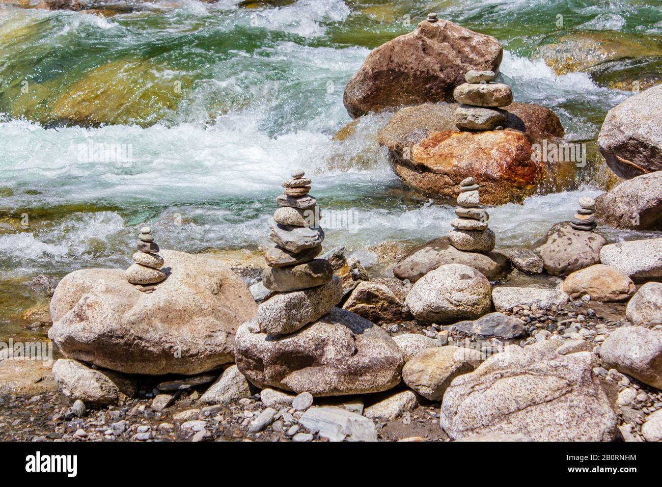 Harmony, Balance und Simplicity Konzept. Eine Steinpyramide auf dem Hintergrund des Flusswassers. Einfache poise Kieselsteine, Rock zen. Blau, Leben. Stockfoto