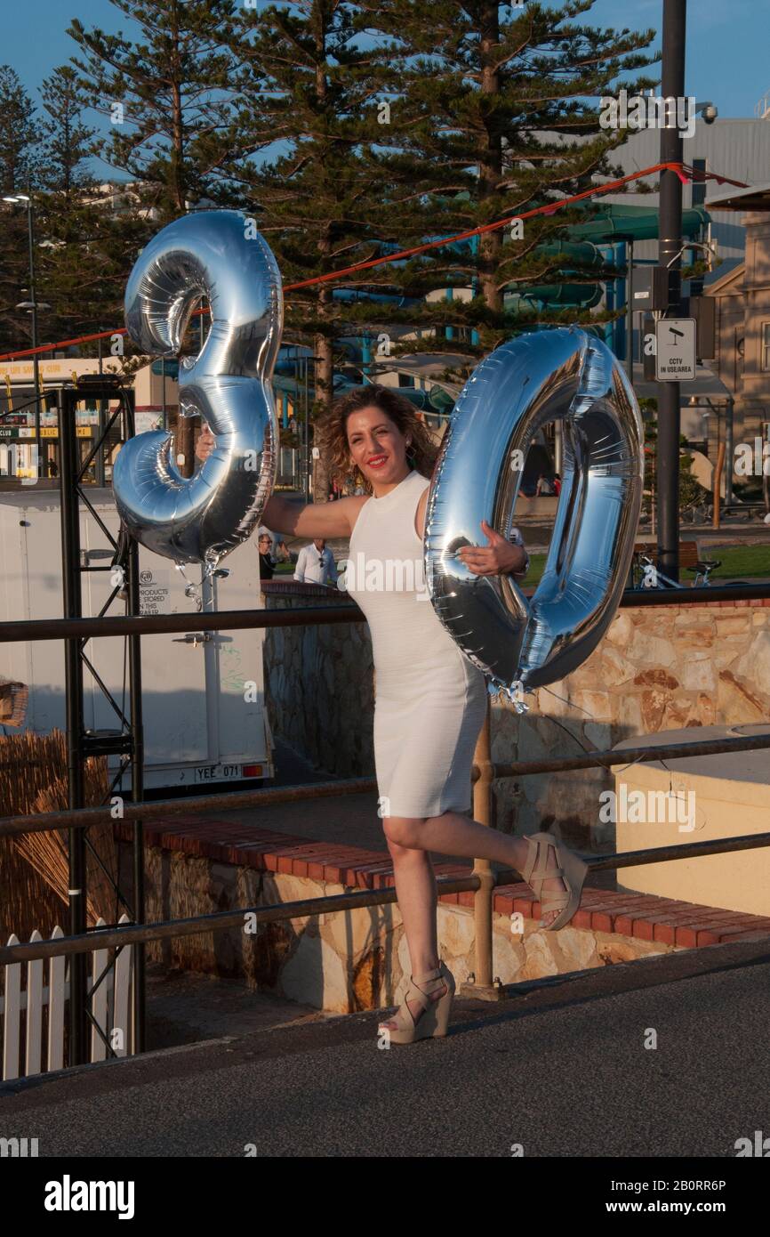 Eine junge Frau feiert ihren dreißigsten Geburtstag mit Freunden am Pier in Glenelg, South Australia Stockfoto