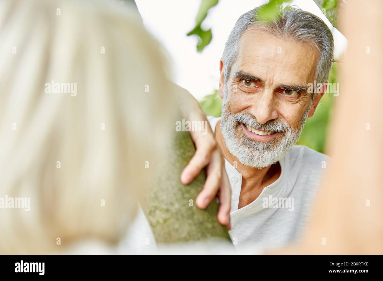 Der alte Mann flirtet im Sommer mit einer Frau in der Natur Stockfoto