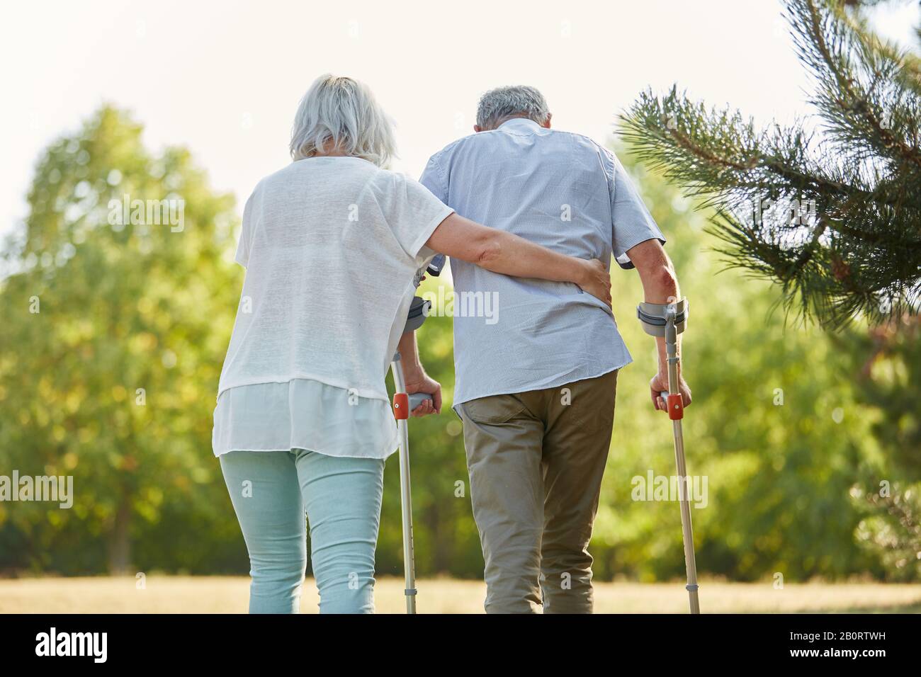 Senior mit Gehstock beim gehen in Reha im Garten Stockfoto